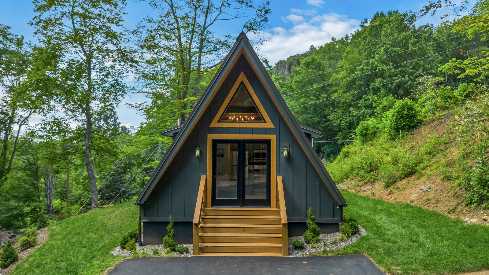 High Peak front elevation in daylight, navy siding and wood trim
