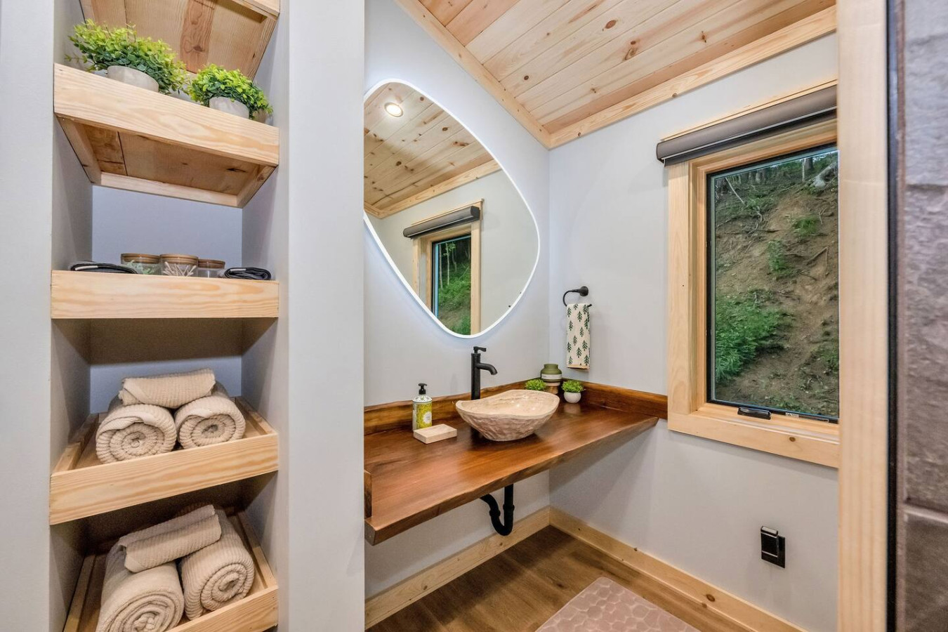 Spa bathroom vanity with live-edge wood counter, vessel sink, and backlit mirror