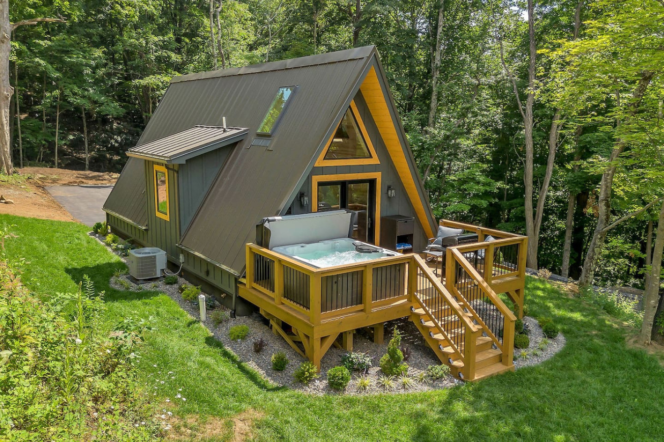 High Peak A-frame in daylight with yellow trim, deck, grill, and XL hot tub