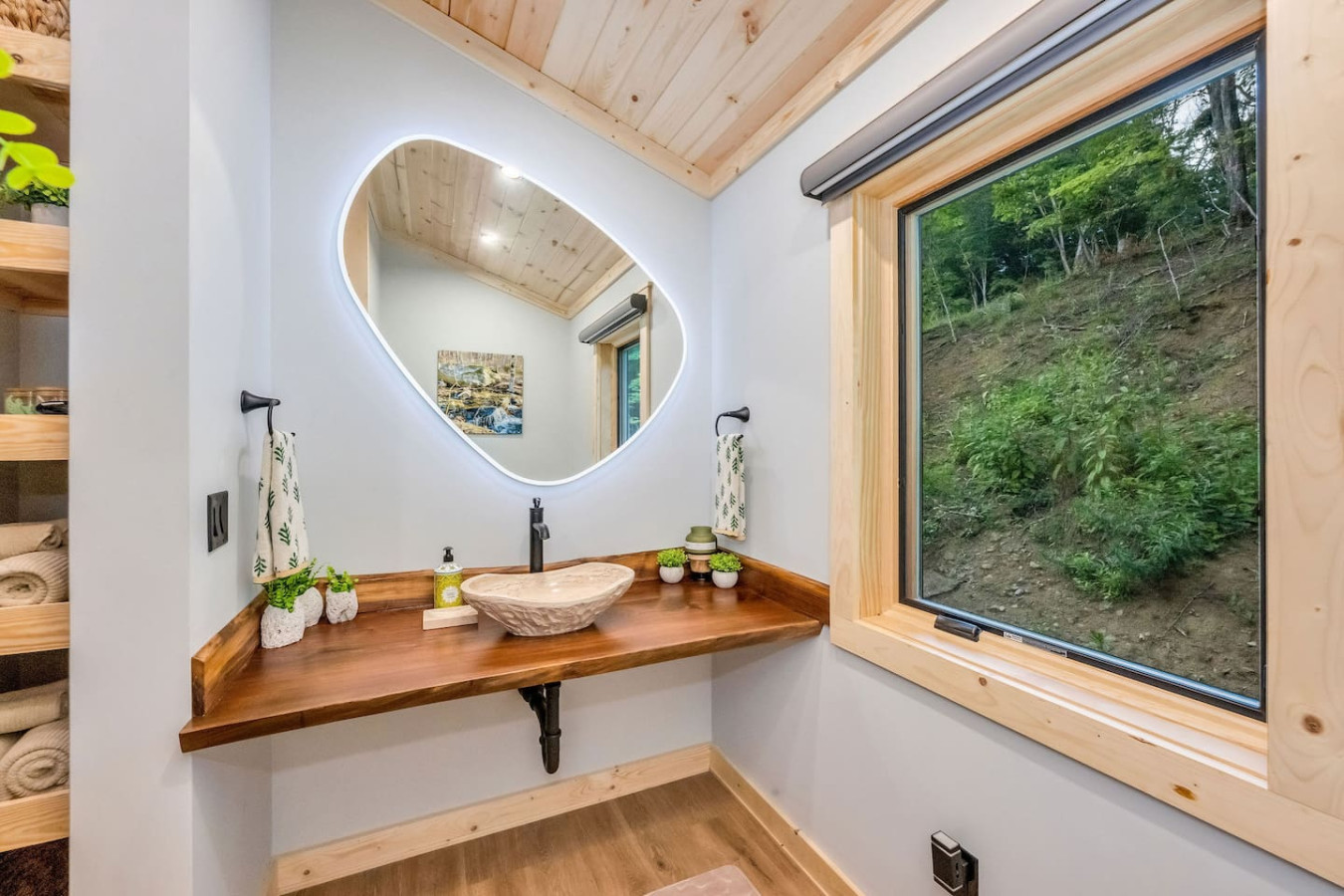 Live-edge vanity with stone vessel sink and backlit mirror