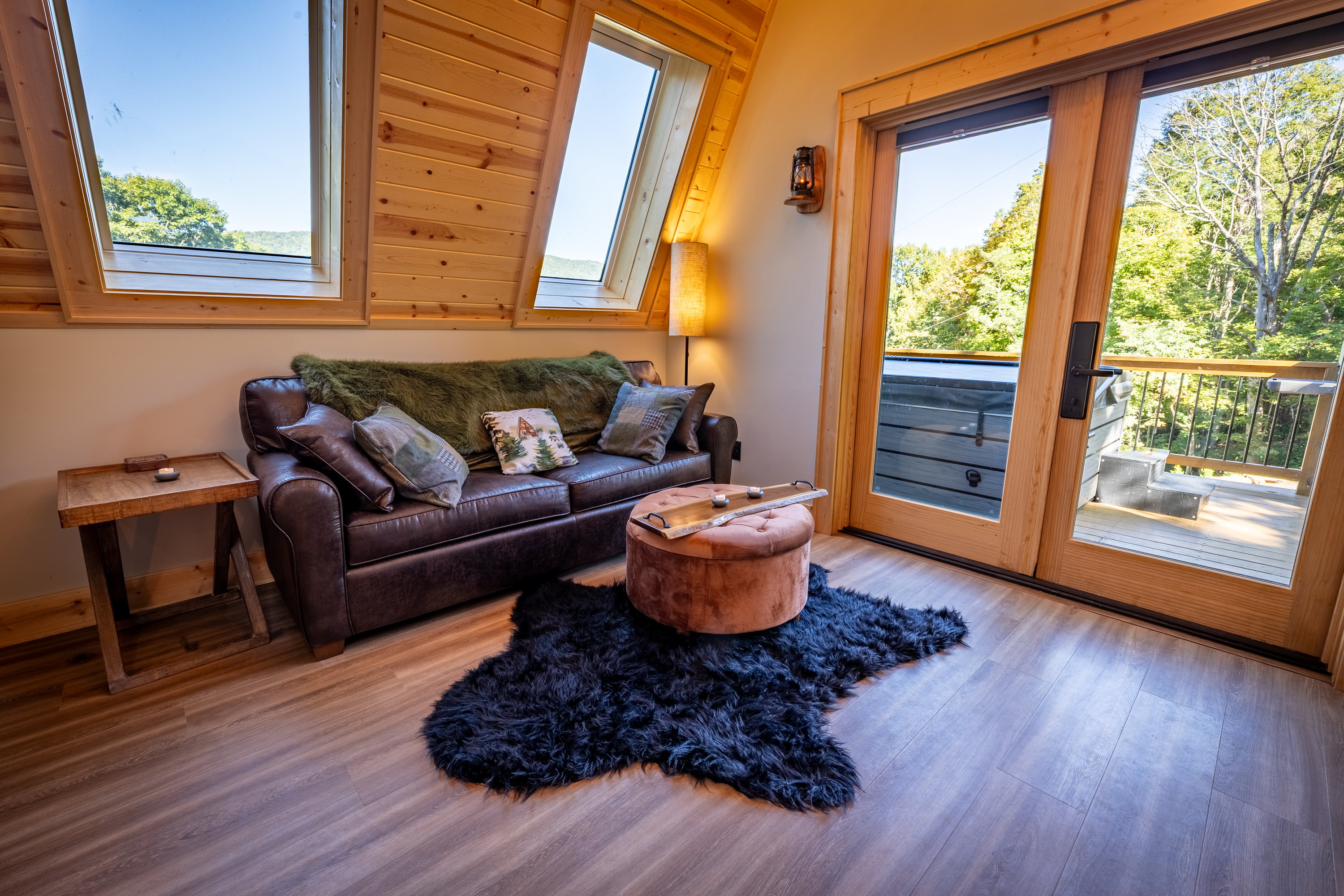 Living room with leather sofa, skylights, and deck view at the Nature cabin in West Jefferson, NC